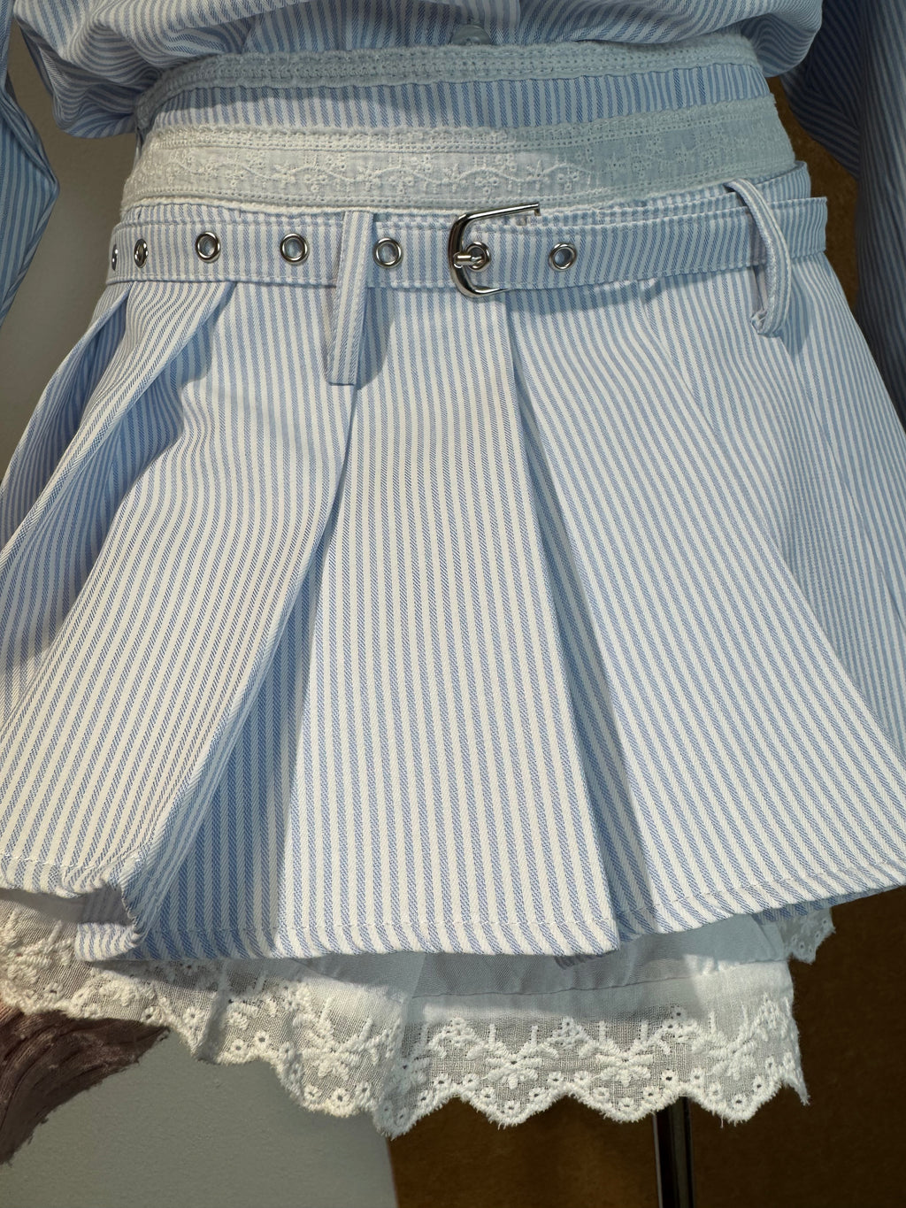 High-Waist Pinstripe Pleated Mini Skirt with Broderie Anglaise Waistband and Grommet Belt | Kallie